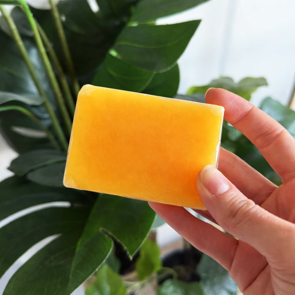 Hand holding the bare turmeric bar